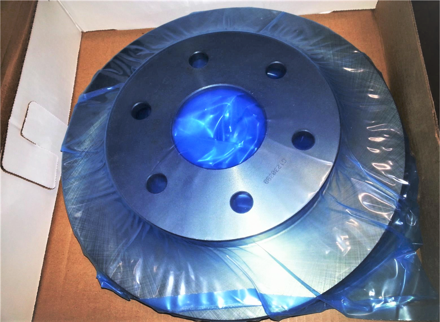 Car part in box wrapped in blue VCI film