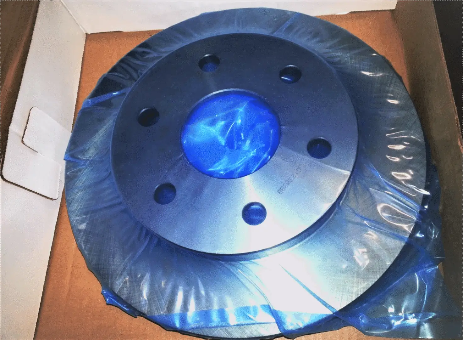 Car part in box wrapped in blue VCI film