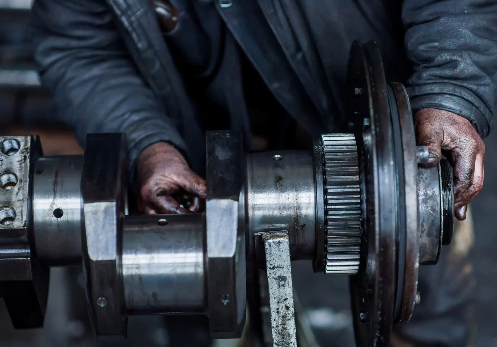Man with oily hands working on large engine part