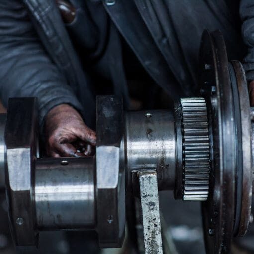 Man with oily hands working on large engine part